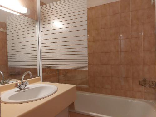 une salle de bain avec un lavabo, une baignoire et un miroir dans l'établissement Studio cabine 4 pers à Vallandry, terrasses sud/ouest, proche pistes et commerces - FR-1-411-137, à Landry