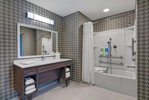 y baño con lavabo, bañera y ducha. en Home2 Suites by Hilton Fort Myers Colonial Blvd en Fort Myers