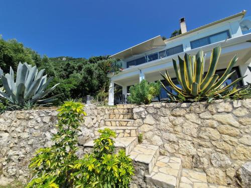 a stone wall in front of a house at Villa Olivia in Pentati