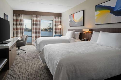 una camera d'albergo con due letti e una televisione di Hilton Garden Inn Camden Waterfront Philadelphia a Camden