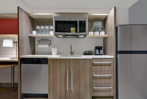 a kitchen with a refrigerator and a microwave at Home2 Suites By Hilton Largo, Fl in Largo