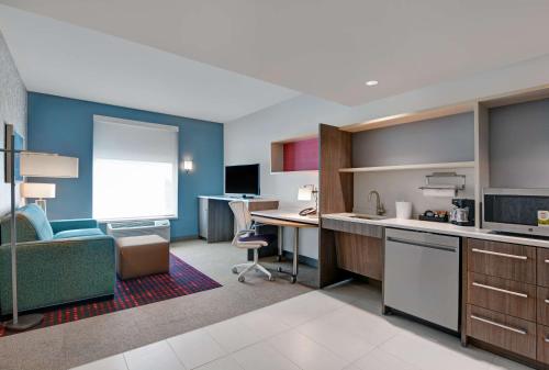 a room with a kitchen and a desk with a computer at Home2 Suites By Hilton Largo, Fl in Largo