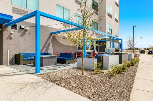 a tree in front of a building with blue benches at Tru By Hilton Midland, Tx in Midland