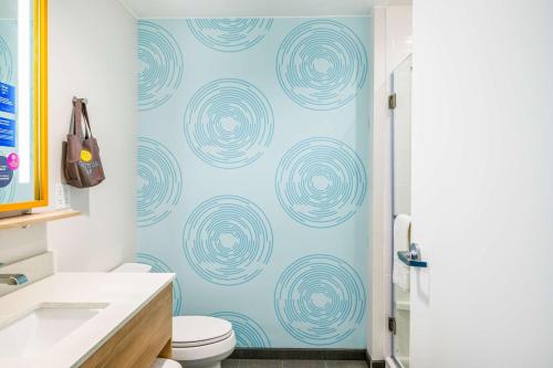 a bathroom with a toilet and a blue wall at Tru By Hilton Midland, Tx in Midland