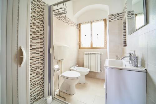 uma casa de banho branca com um WC e um lavatório em Elysee em La Spezia