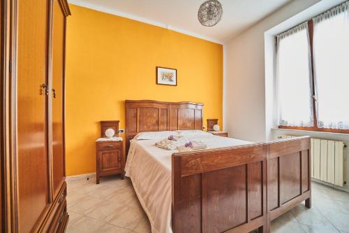 um quarto com uma cama e uma parede amarela em Elysee em La Spezia