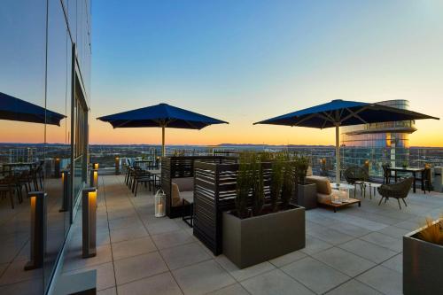 a rooftop patio with tables and umbrellas on a building at Embassy Suites by Hilton Nashville Downtown in Nashville
