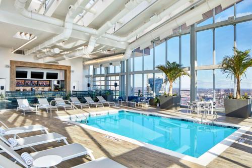 a pool with chairs and tables in a building with windows at Embassy Suites by Hilton Nashville Downtown in Nashville