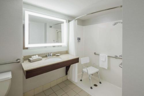 uma casa de banho com um lavatório, um WC e um espelho. em Hotel Trilogy Albany Airport, Tapestry Collection by Hilton em Latham