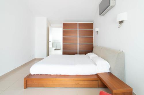 a bedroom with a bed with a wooden headboard at Sand Bay Beach Duplex in Girona