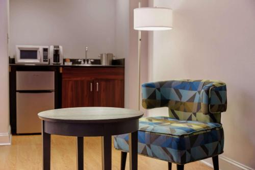 a table and a chair in a room at Hotel Trilogy Albany Airport, Tapestry Collection by Hilton in Latham