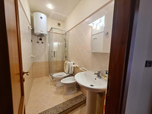 a bathroom with a toilet and a sink and a shower at Casa Igea in Siracusa