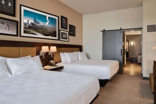 a hotel room with two beds and a room with two lamps at Embassy Suites by Hilton Nashville Downtown in Nashville