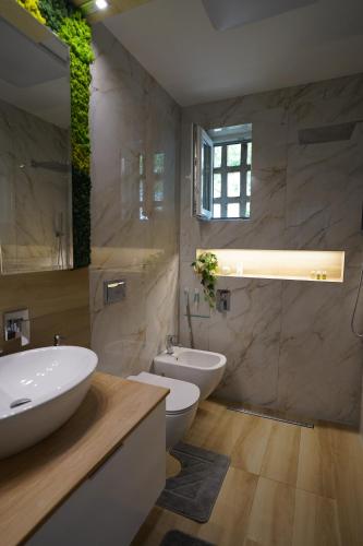 ein Badezimmer mit zwei Waschbecken, einer Badewanne und zwei WCs in der Unterkunft The Zen Den in Cluj-Napoca