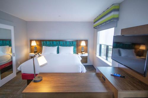 a hotel room with a bed and a flat screen tv at Hampton Inn North Attleboro, Ma in North Attleboro