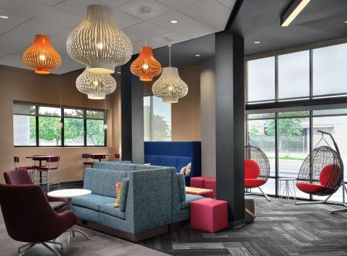 a lobby with a blue couch and red chairs at Tru By Hilton Indianapolis Downtown, In in Indianapolis