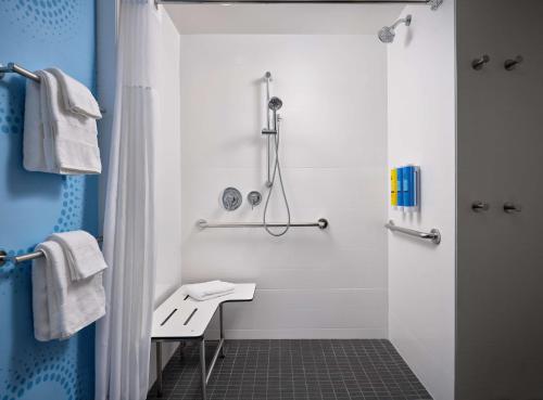 a white bathroom with a shower and a sink at Tru By Hilton Indianapolis Downtown, In in Indianapolis