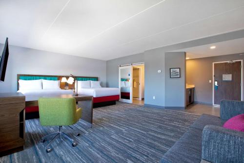 オタワにあるHampton Inn & Suites Ottawa West, Ontario, Canadaのベッドとデスクが備わるホテルルームです。