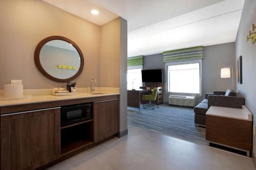 La salle de bains est pourvue d'un lavabo et d'un miroir. dans l'établissement Hampton Inn & Suites Ottawa West, Ontario, Canada, à Ottawa