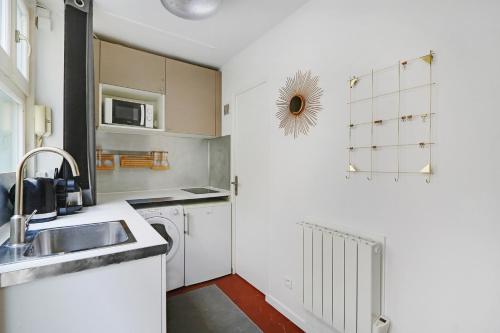 une cuisine avec un évier et un lave-vaisselle dans l'établissement Pick A Flat's Apartment in Montorgueil - Rue Léopold Bellan, à Paris