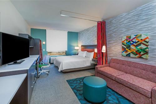 Habitación de hotel con cama y sofá en Home2 Suites By Hilton Midland East, Tx, en Midland