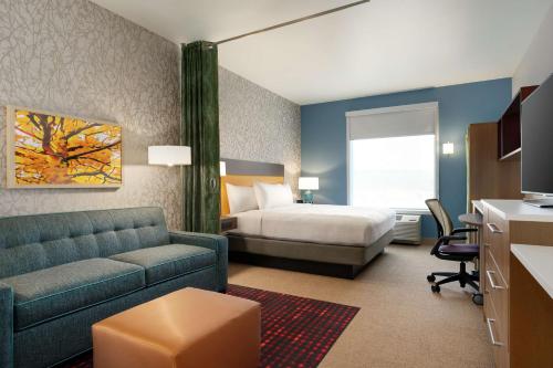 a hotel room with a bed and a couch at Home2 Suites By Hilton Martinsburg, Wv in Martinsburg