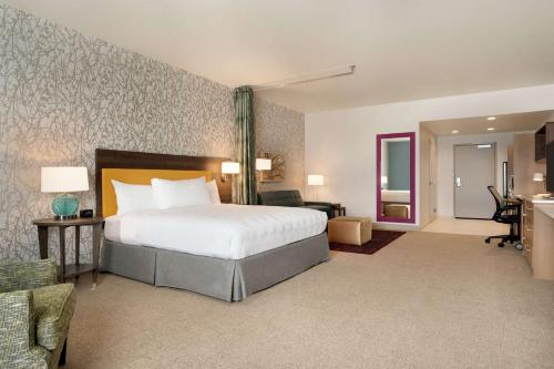 a bedroom with a bed and a living room at Home2 Suites By Hilton Martinsburg, Wv in Martinsburg