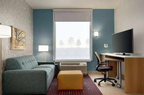 a living room with a couch and a desk with a computer at Home2 Suites By Hilton Martinsburg, Wv in Martinsburg