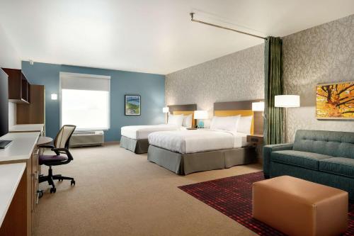 a hotel room with two beds and a couch at Home2 Suites By Hilton Martinsburg, Wv in Martinsburg