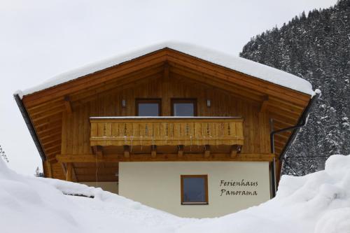 a building with a balcony in the snow at Ferienhaus Panorama in Biberwier