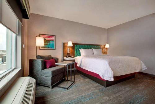 a hotel room with a bed and a chair at Hampton Inn Brockville, On in Brockville