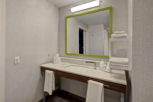 a bathroom with a sink and a mirror and towels at Hampton Inn Brockville, On in Brockville