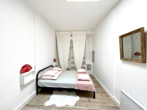 a bedroom with a bed with pink sheets and a mirror at Ravissant appartement à 50m port + Parking in La Ciotat