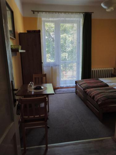 sypialnia z łóżkiem, biurkiem i oknem w obiekcie WILLA "SZCZĘSNA" w mieście Piwniczna