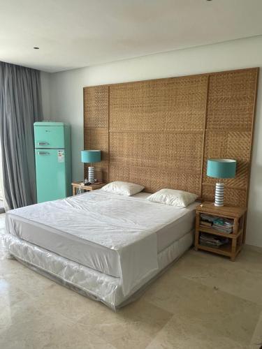een slaapkamer met een groot bed en een blauwe koelkast bij Villa Dada in M'diq