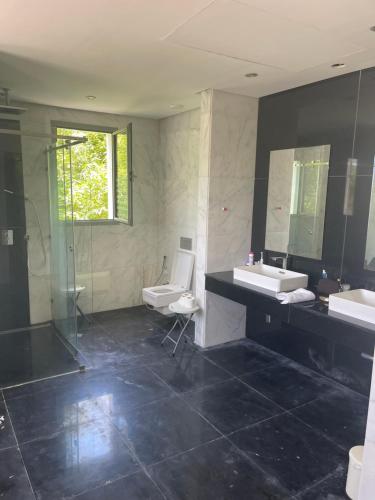 een badkamer met 2 wastafels, een douche en 2 toiletten bij Villa Dada in M'diq