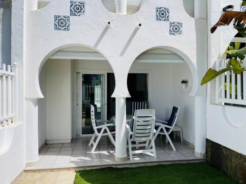 a patio with chairs and a table in a house at Bungalow Monte Golf in Playa del Ingles