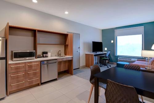 a room with a kitchen and a dining room at Home2 Suites by Hilton North Plano Hwy 75 in Plano