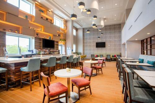 a restaurant with tables and chairs and a bar at Hampton Inn & Suites North Port, Fl in North Port