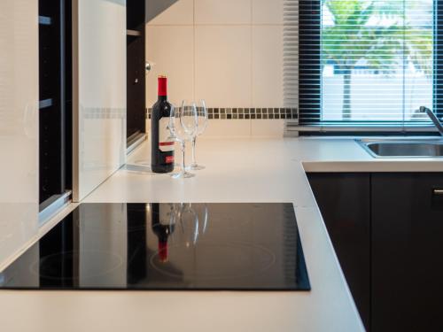 a bottle of wine and two wine glasses on a kitchen counter at Casa Mimi - your perfect family getaway in Corralejo