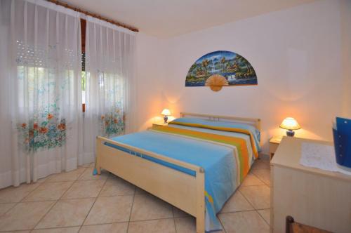 een slaapkamer met een bed, 2 lampen en een raam bij Paolino Housing in Paestum