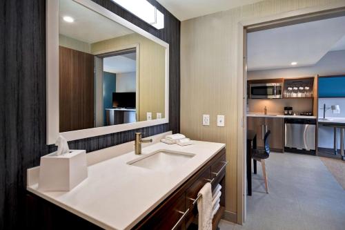 a bathroom with a sink and a large mirror at Home2 Suites By Hilton Bowling Green, Oh in Bowling Green