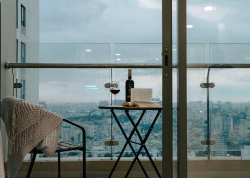 una mesa con una botella de vino y una copa en Louisa The Gold View Apartment, en Ho Chi Minh