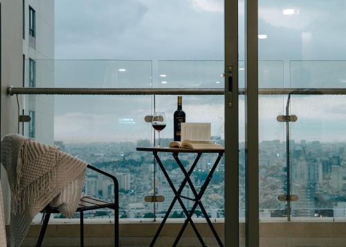 a table with a bottle of wine and a glass at Louisa The Gold View Apartment in Ho Chi Minh City