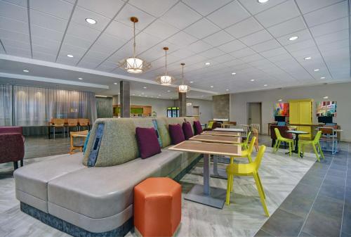 a lobby with a couch and tables and chairs at Home2 Suites By Hilton Raleigh North I-540 in Raleigh