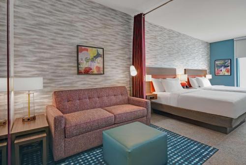 Habitación de hotel con cama y sofá en Home2 Suites By Hilton Raleigh North I-540 en Raleigh