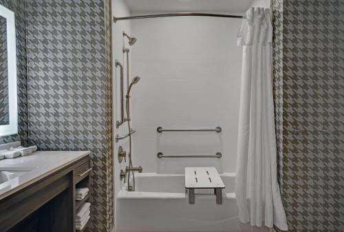 a bathroom with a shower and a tub and a sink at Home2 Suites By Hilton Raleigh North I-540 in Raleigh