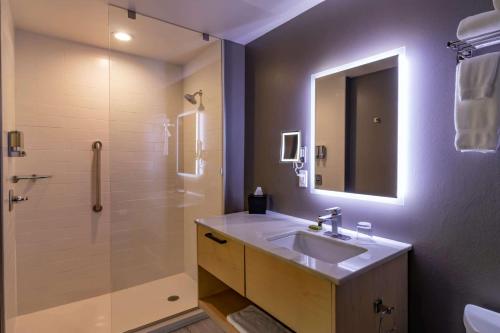 een badkamer met een wastafel en een douche met een spiegel bij The Waters Hot Springs, Tapestry Collection by Hilton in Hot Springs