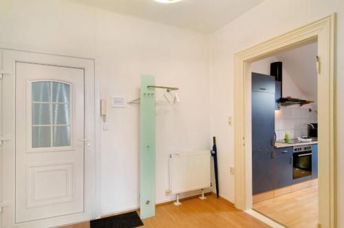 Habitación con puerta y cocina con nevera. en Villa Fokken Steuermannsquartier, en Esens