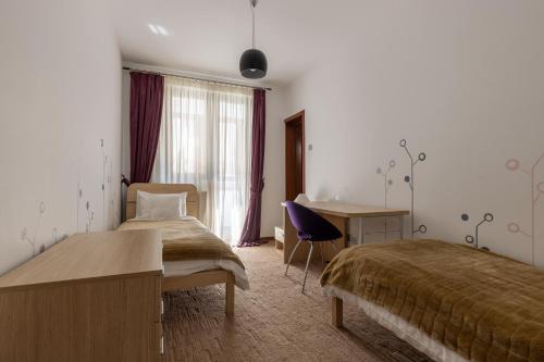 Pokój hotelowy z 2 łóżkami i biurkiem w obiekcie Vila Etiquette w mieście Predeal